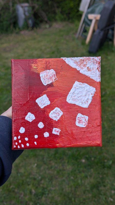 Rote und orangefarbene abstrakte Malerei mit weißen, geometrischen Formen.